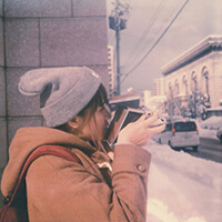 Girl taking photos with Polaroid SX-70 film camera in Hokkaido, Japan